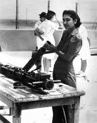 A Sikh woman working on a gun during WWII.