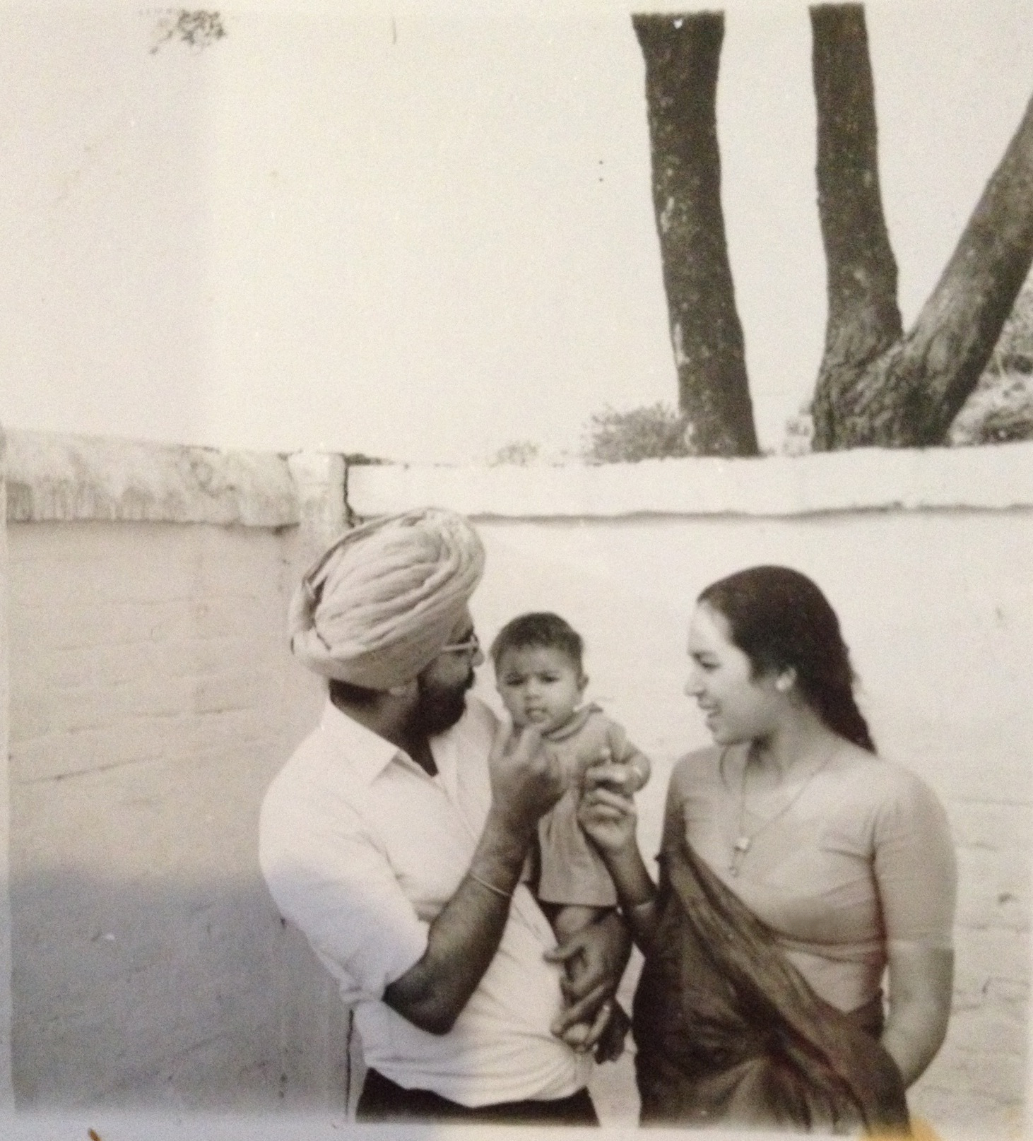 1968 Punjab family photo of Sarjeet Kaur and her husband holding their daughter.